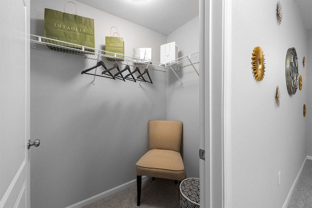 a room with a chair and a closet with shelves