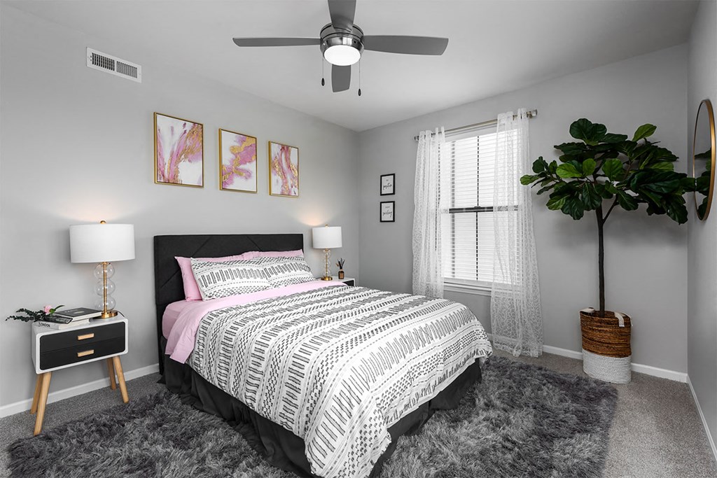 a bedroom with a bed and a ceiling fan