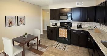 a kitchen with black cabinets and a wooden table