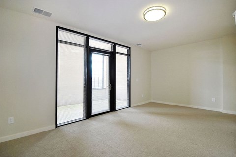 A room with a sliding glass door leading to a balcony.