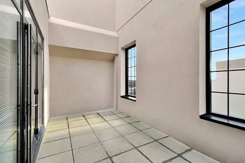 A room with a tiled floor and a window with a view of the sky.