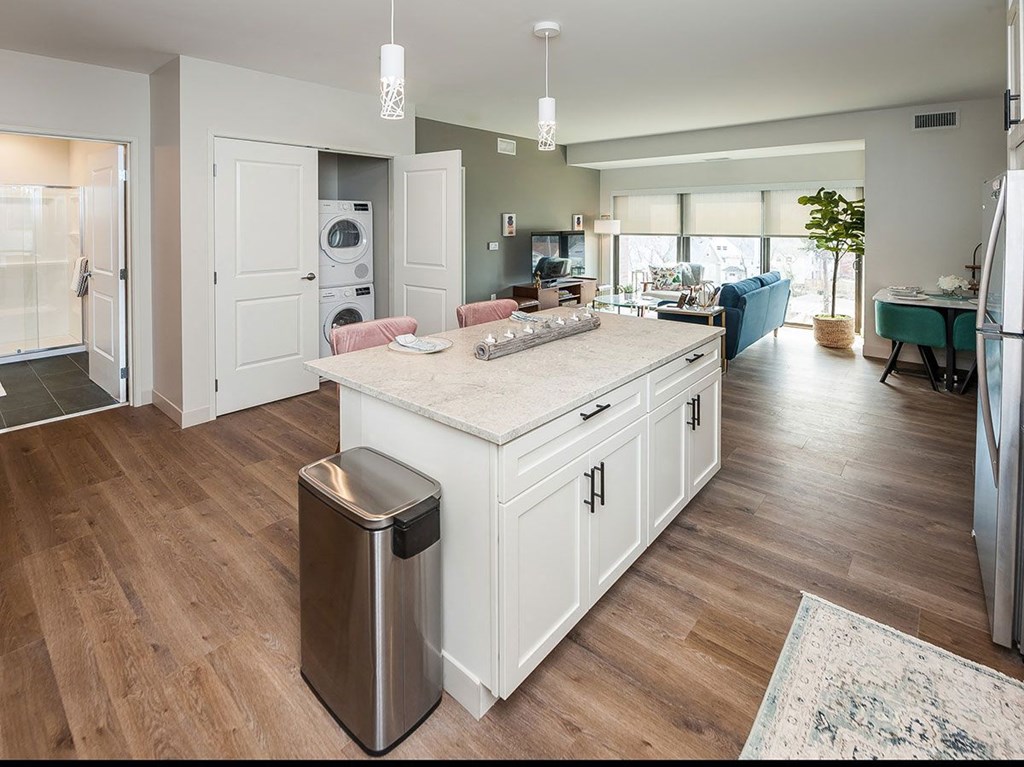 A modern kitchen with a large island and a trash can.