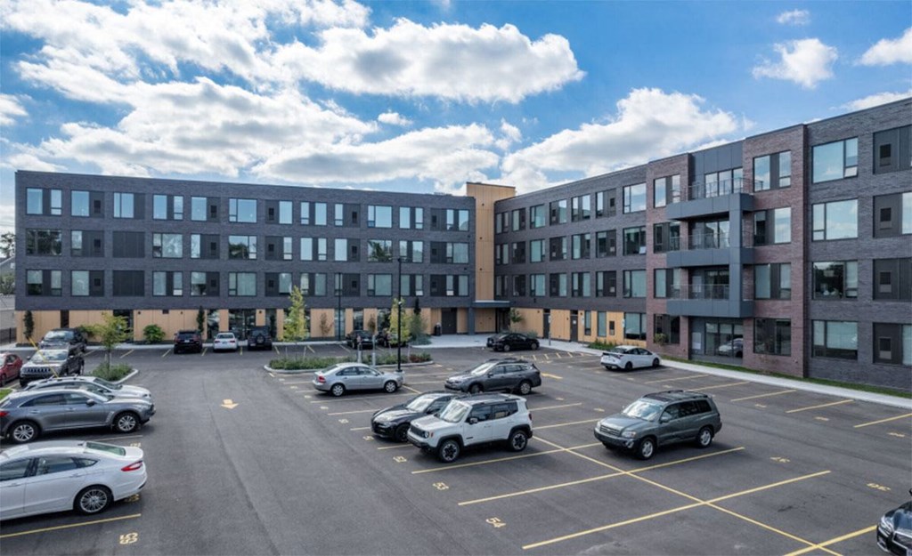 A parking lot with cars and a building in the background.