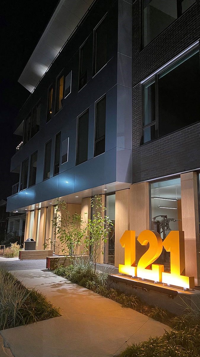 A modern building with the number 121 illuminated in front.