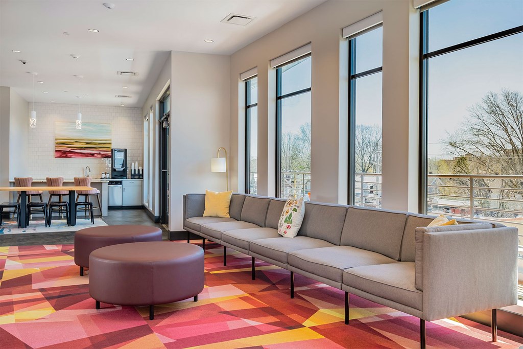 A modern living room with a grey sofa and a red and yellow carpet.