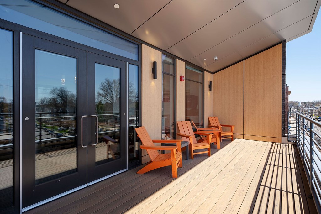 A balcony with wooden floors and chairs.