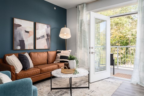a living room with a brown couch and a door to a patio