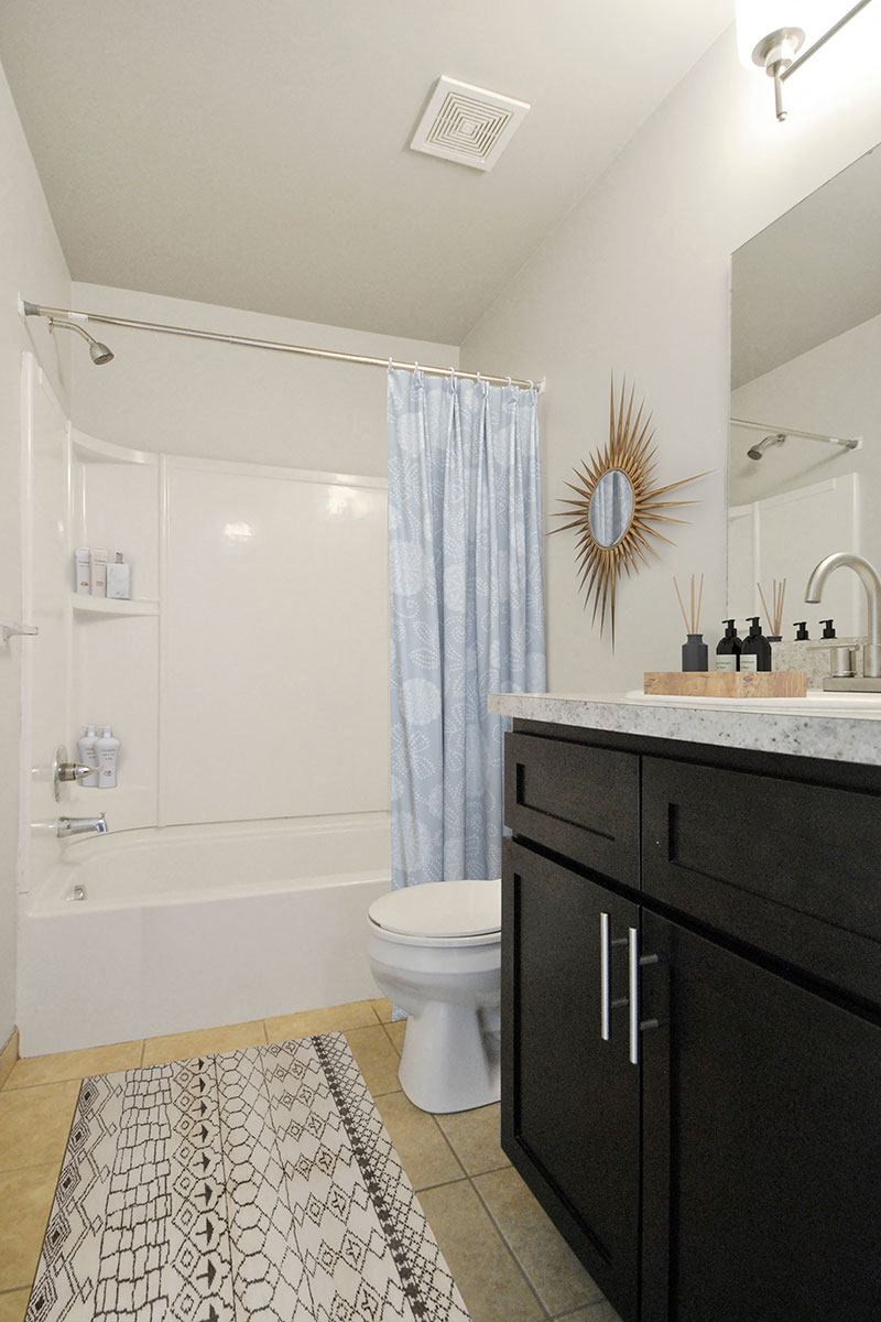 bathroom with a bathtub and dark cabinet