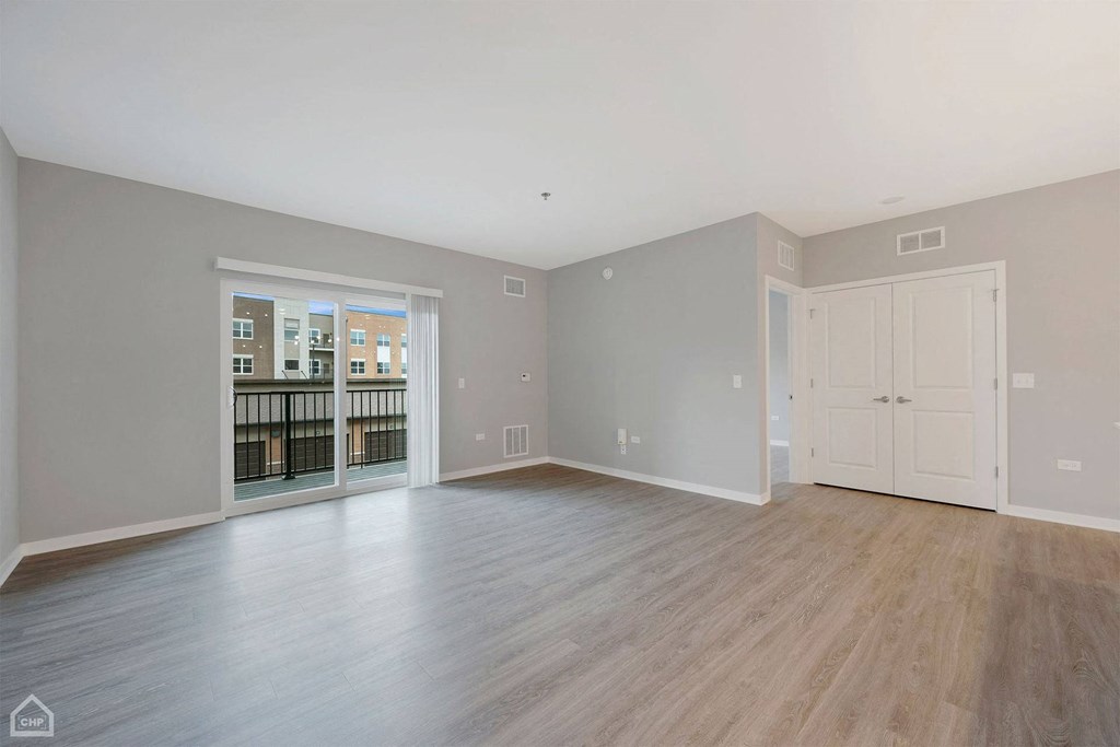 an empty living room with a door to a balcony