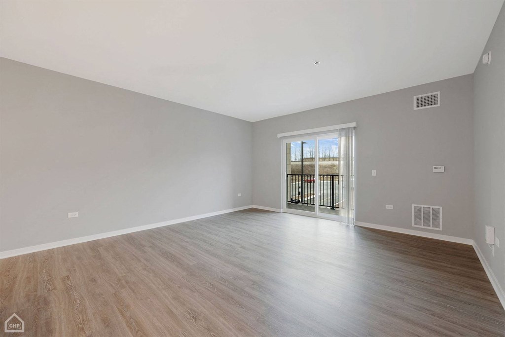 the living room is spacious and has a sliding glass door to the balcony