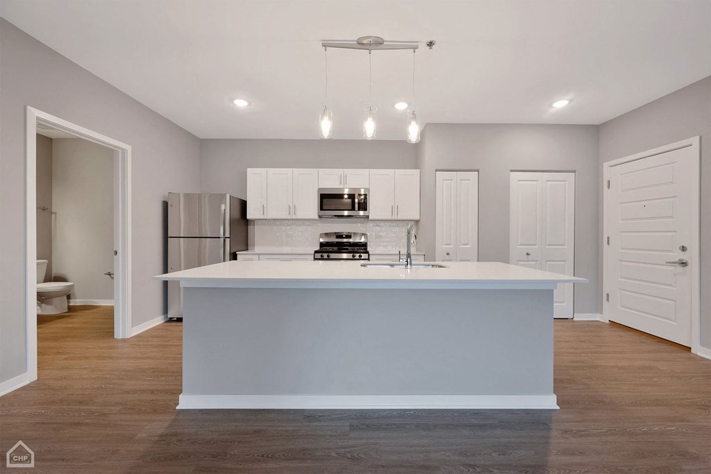 a white kitchen with a large island in the middle