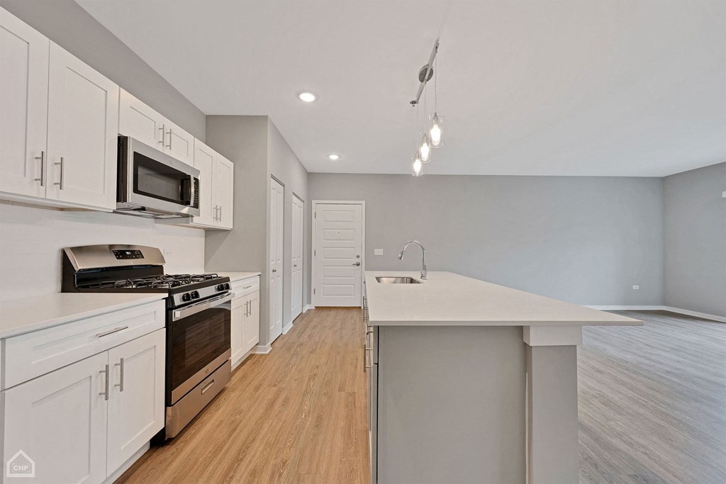 a kitchen with white cabinets and stainless steel appliances