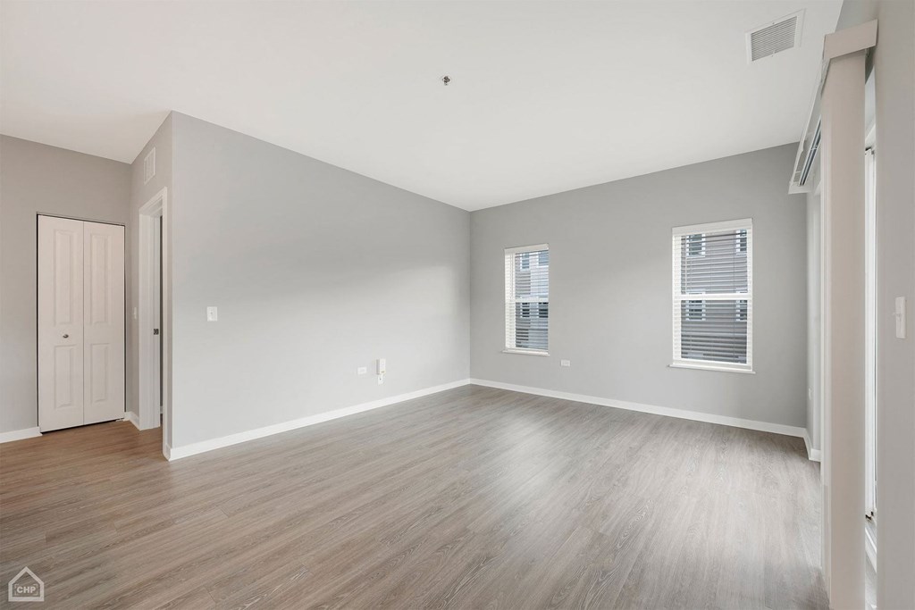 an empty living room with wood floors and white walls