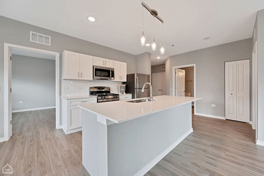 an open kitchen with a large island with a sink