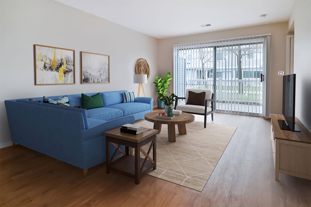 A blue couch sits in a living room with a wooden coffee table in front of it.