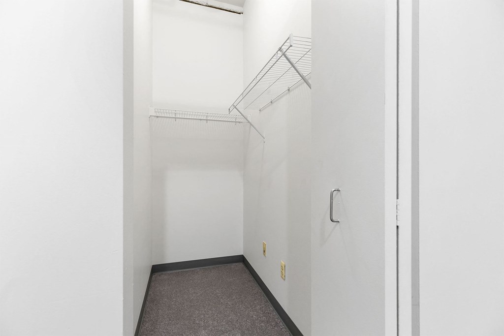 an empty room with white walls and a white closet