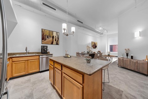 A kitchen with wooden cabinets and a marble countertop.