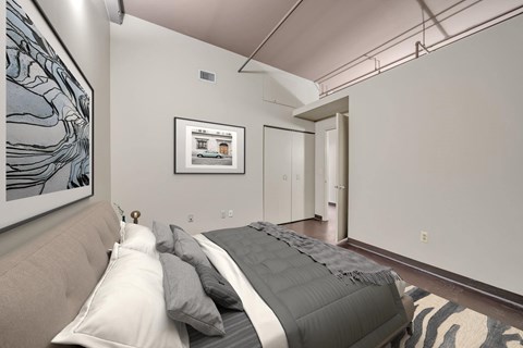A bedroom with a bed and a picture on the wall.