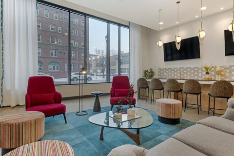 A living room with a red chair and a glass table.