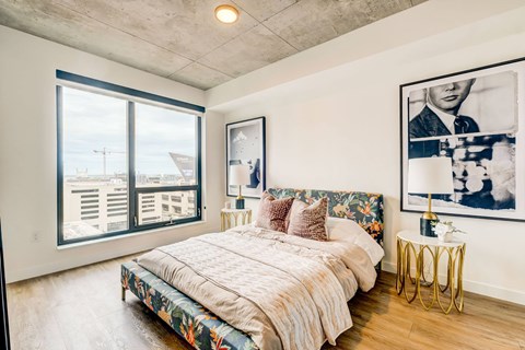 A bedroom with a large bed and a picture on the wall.