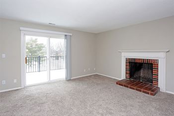 a living room with a fireplace and a sliding glass door