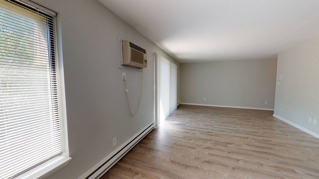 a empty room with a wall air conditioner and a window