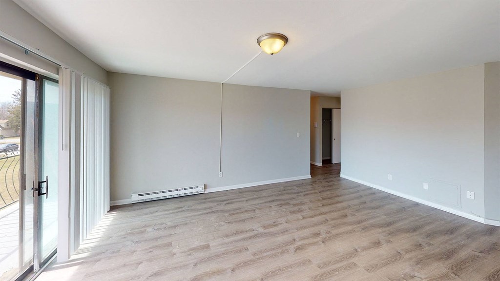 a living room with a wood floor and a sliding glass door