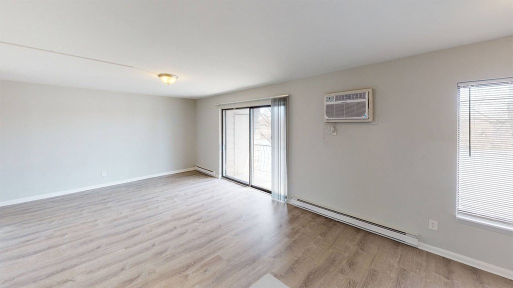 an empty living room with a sliding glass door to a patio