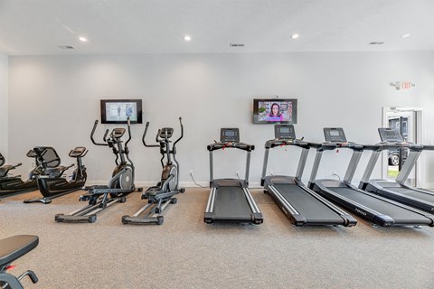A gym with treadmills, exercise bikes, and elliptical machines.