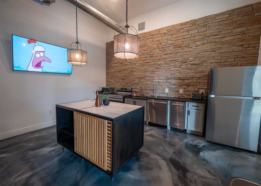 A kitchen with a brick wall and a flat screen tv showing a cartoon character.