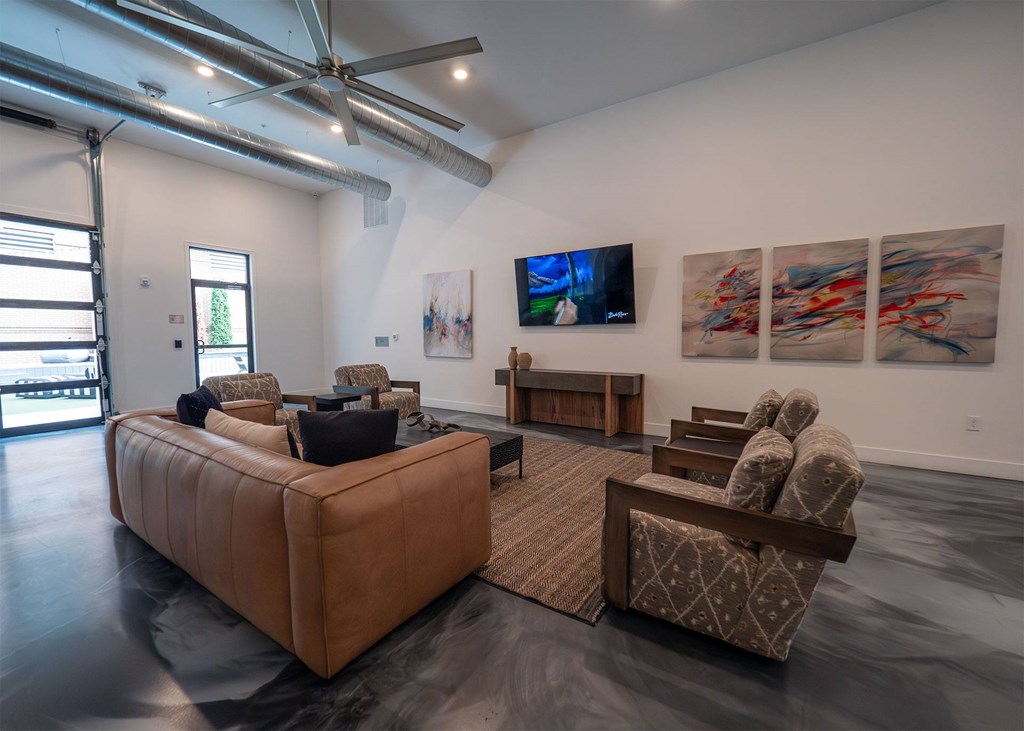 A living room with a brown sofa and a television on the wall.