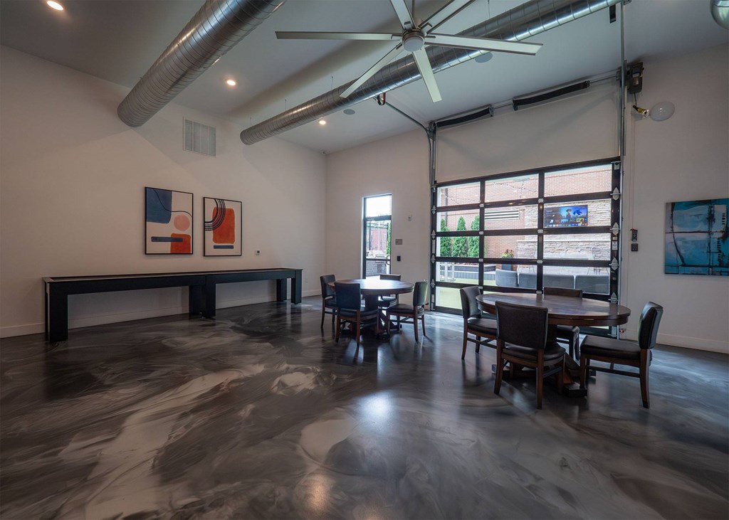 A room with a table and chairs and a ceiling fan.