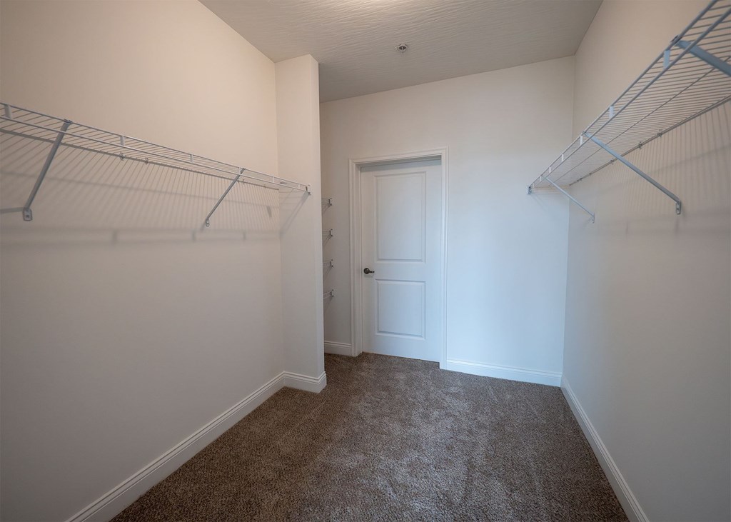 A room with a carpeted floor and a white door.