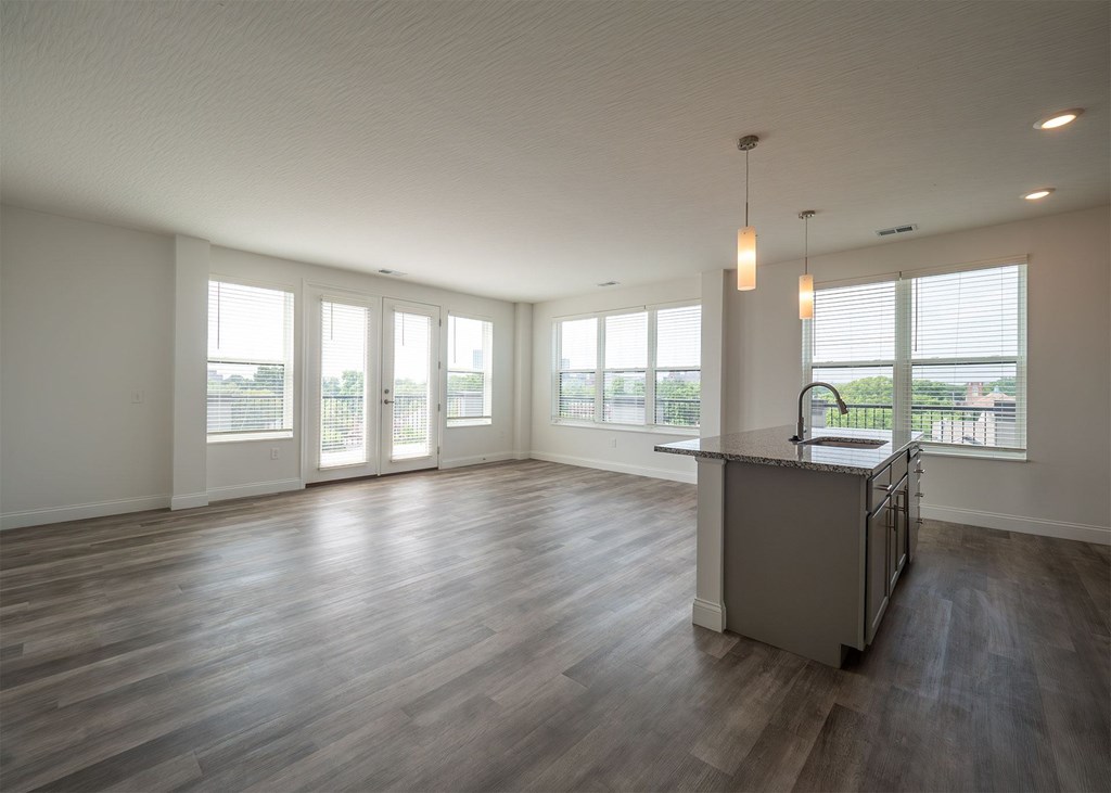 A spacious room with a bar and wooden floors.