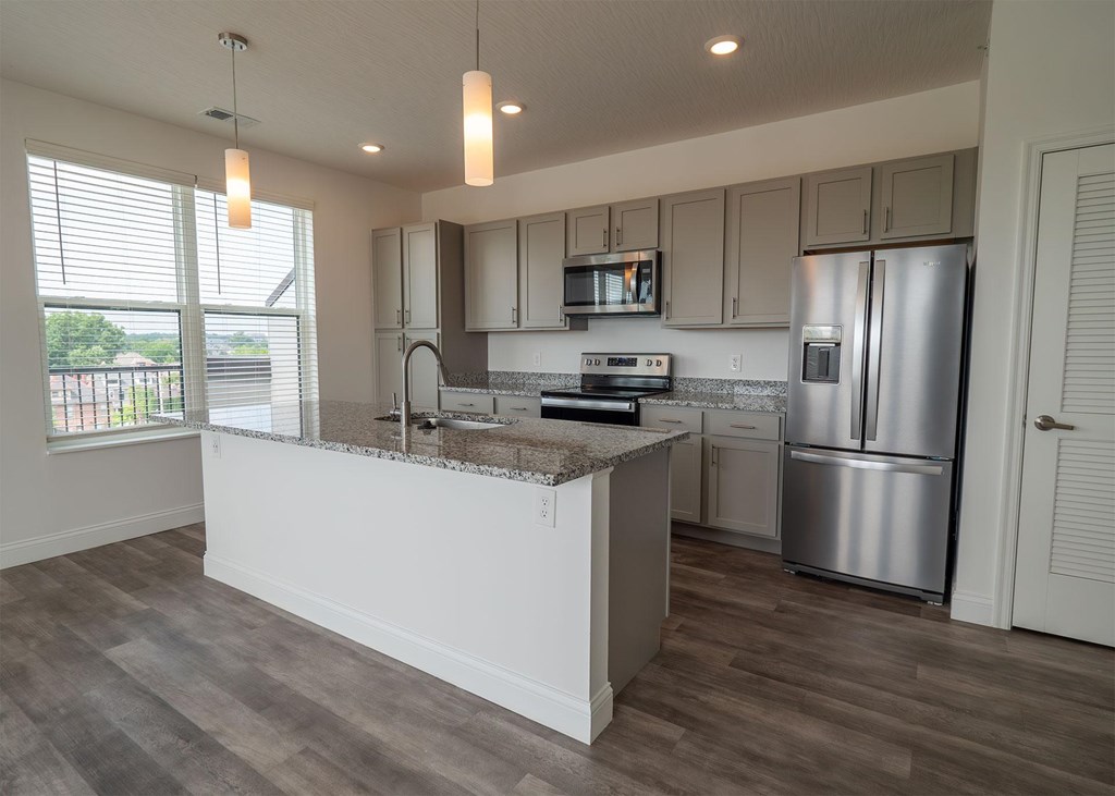 A kitchen with a white counter and stainless steel appliances.