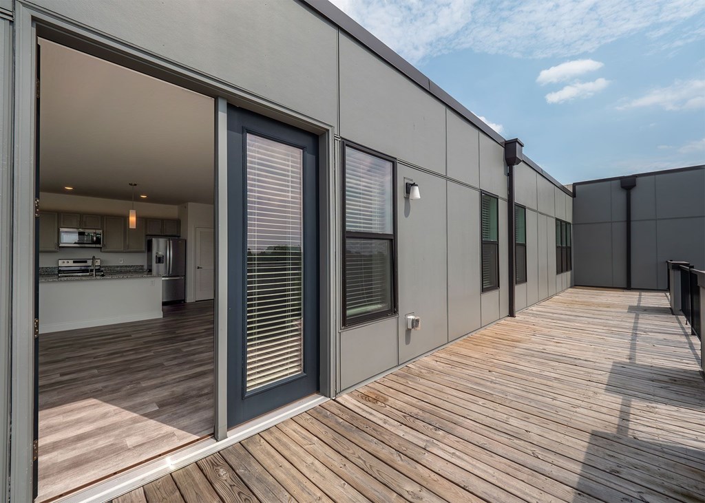 A modern house with a wooden deck and sliding glass doors.