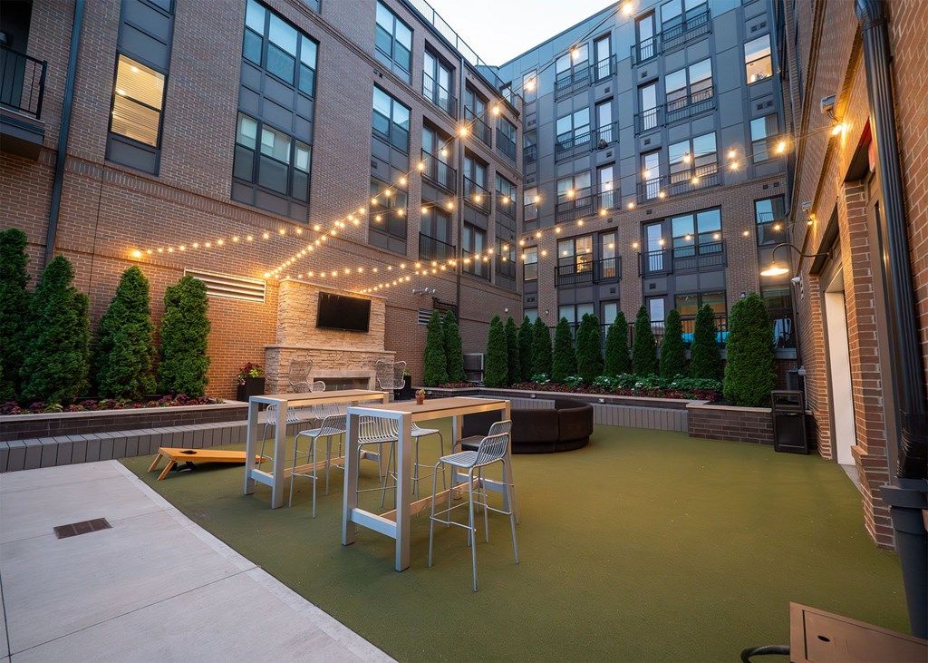 A patio with a table and chairs is surrounded by buildings.