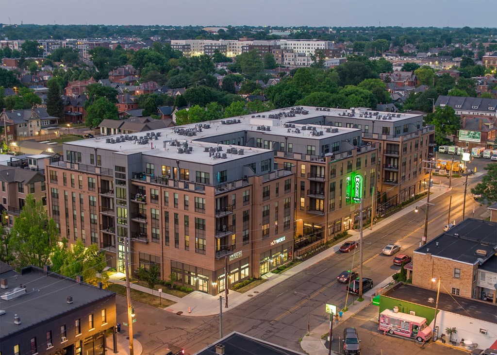 A large apartment complex is lit up at dusk.