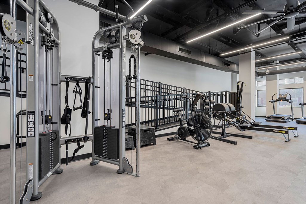 A gym with a variety of equipment including treadmills, weights, and exercise machines.