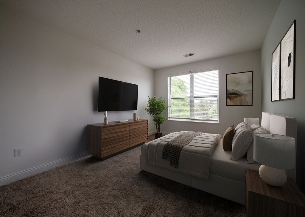 A bedroom with a bed, a television, and a potted plant.