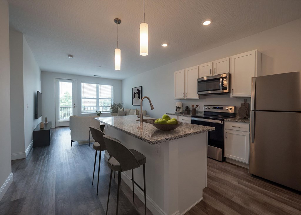 A kitchen with a white island and stainless steel appliances.