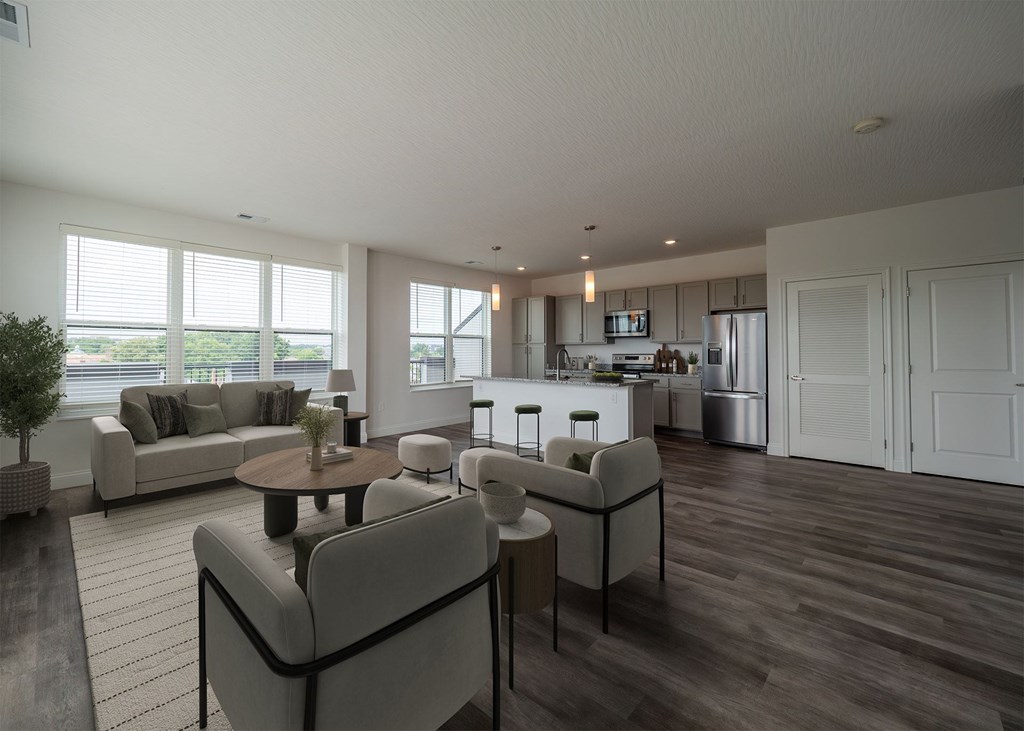 A modern living room with a grey sofa set and a wooden floor.