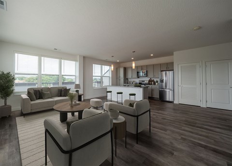 A modern living room with a grey sofa set and a wooden floor.