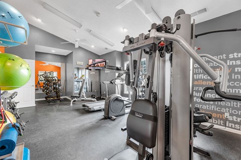 A gym with a variety of equipment including a treadmill, a stationary bike, and a weight machine.