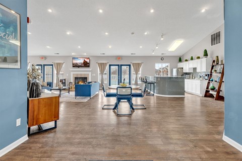 A spacious living room with a blue wall and a wooden floor.