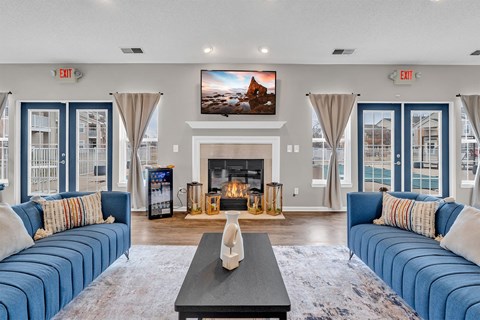 A living room with a fireplace and blue couches.