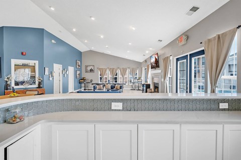 A kitchen with white cabinets and a blue wall.