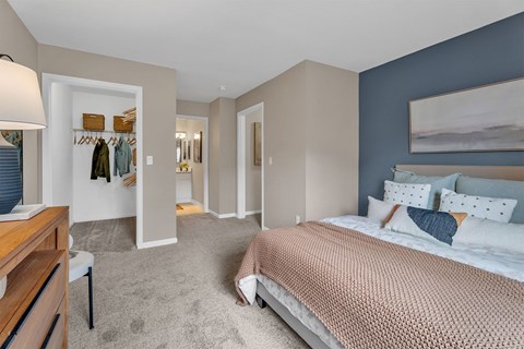 A bedroom with a large bed and a wooden dresser.