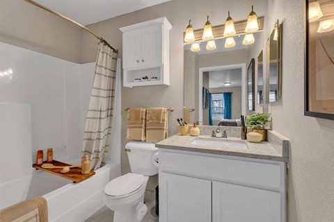 A white toilet sits next to a white sink in a bathroom.