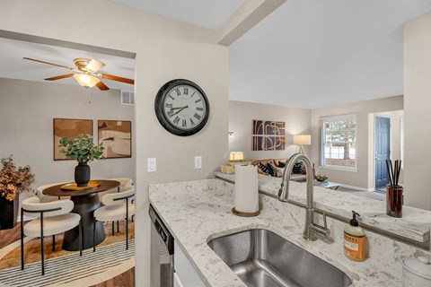 A kitchen with a marble countertop and a ceiling fan.